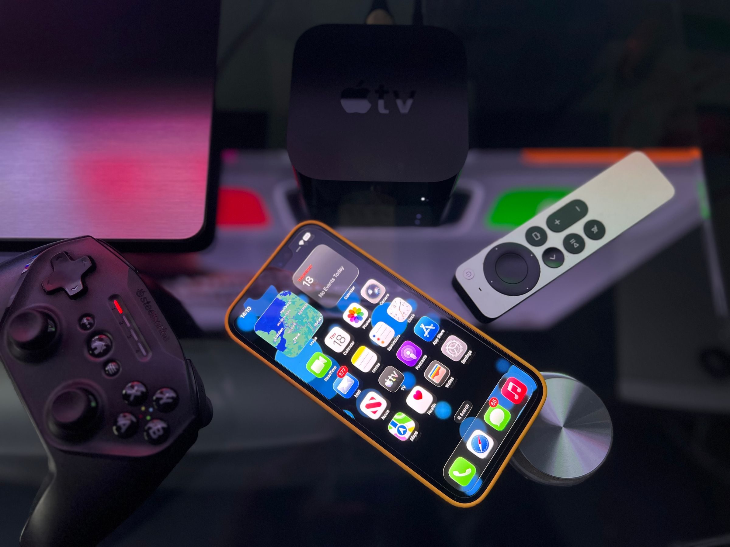 Boîtier multimédia, télécommande et manette sur un meuble TV